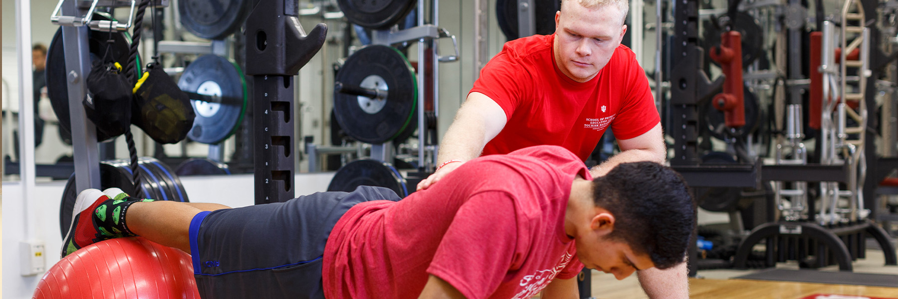 A male student working with another male student personal trainer