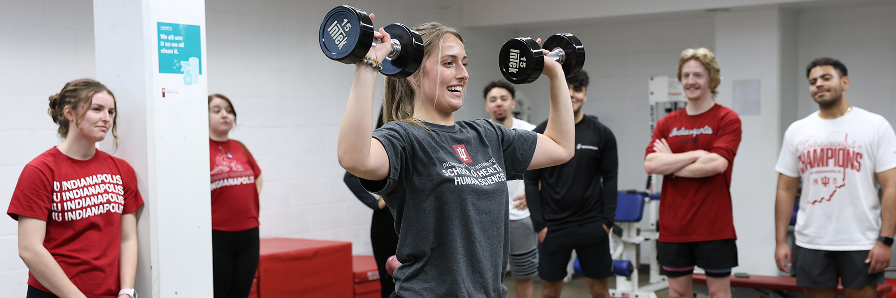 Students in weight room watch classmate lift weights