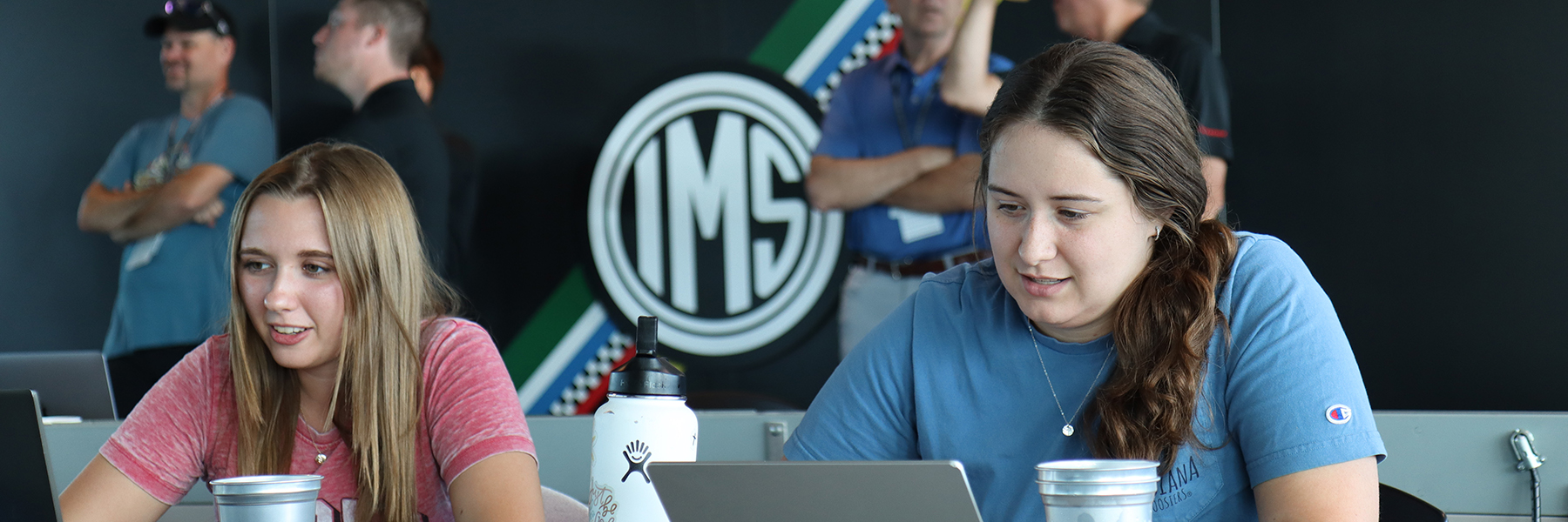 2 students working on laptops at the Indiana Motor Speedway