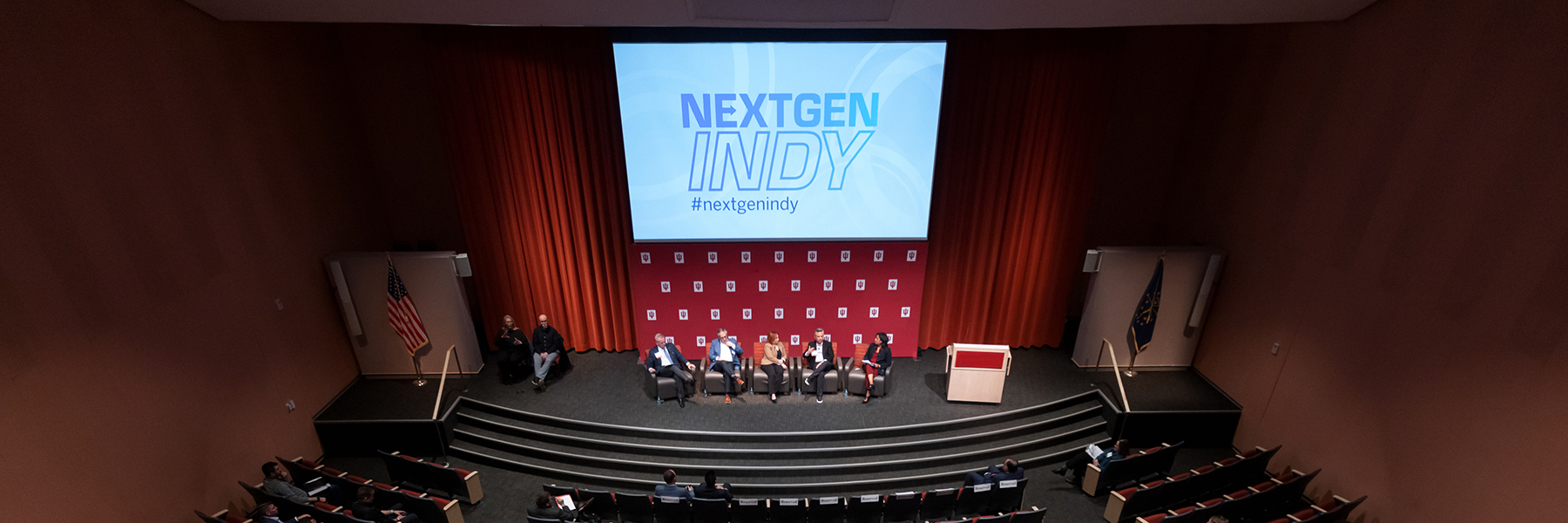 An aerial view of an auditorium stage with IU panelists