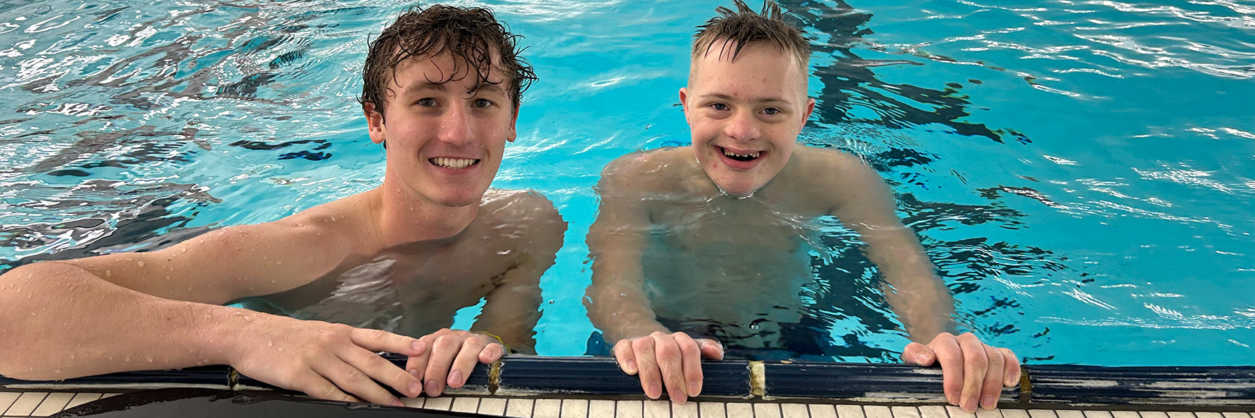 A student coach during a swim class with a participant