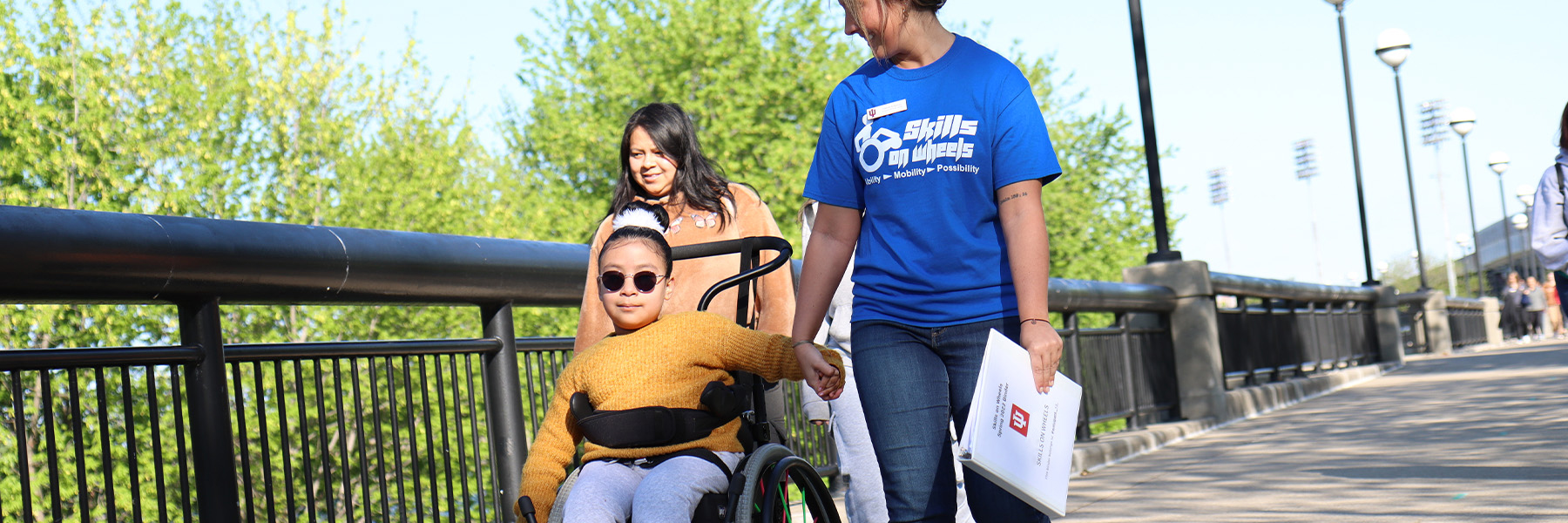 A student walking with a community member participating in Skills on Wheels